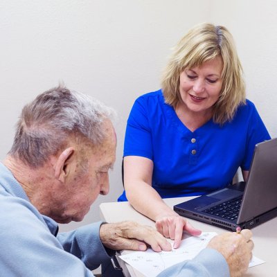 Stock image: A female doctor sitting with an elderly male patient